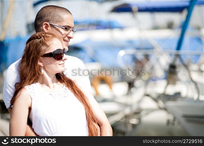 Man and woman looking away while standing at harbour