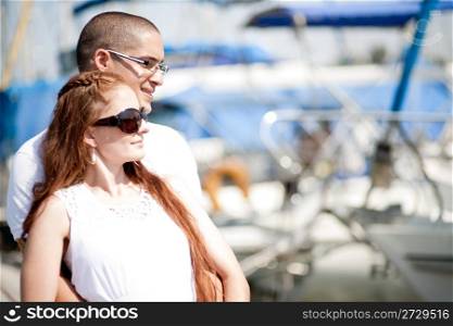Man and woman looking away while standing at harbour