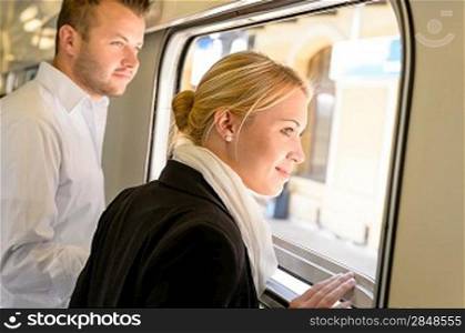 Man and woman looking out train window smiling travel commuters