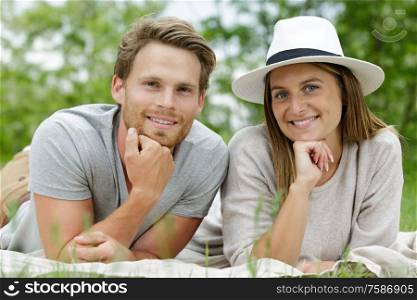 man and woman lying on the grass posing
