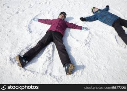 Man and Woman Lying on the Snow Making Snow Angel