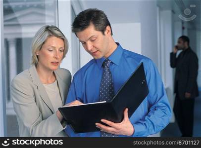 man and woman meeting in office and discussing document