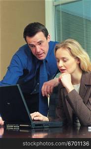 man and woman meeting in office and discussing work on laptop