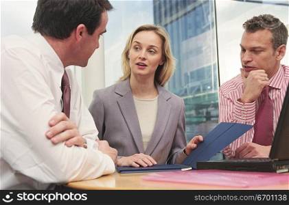 man and woman meeting in office discussing document
