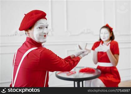 Man and woman, mime artists, scene with gift. Pantomime theater, parody comedian, positive emotion, humour performance, funny face mimic and grimace. Man and woman, mime artists, scene with gift
