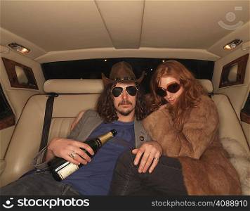 Man and woman on backseat of luxury car