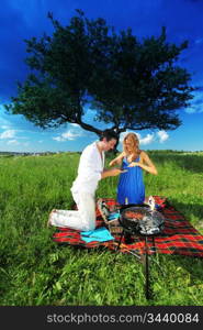 man and woman on picnic in green grass