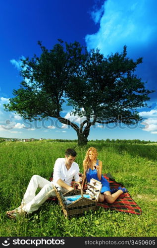 man and woman on picnic in green grass