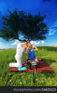 man and woman on picnic in green grass