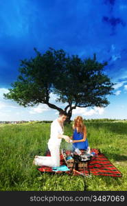 man and woman on picnic in green grass