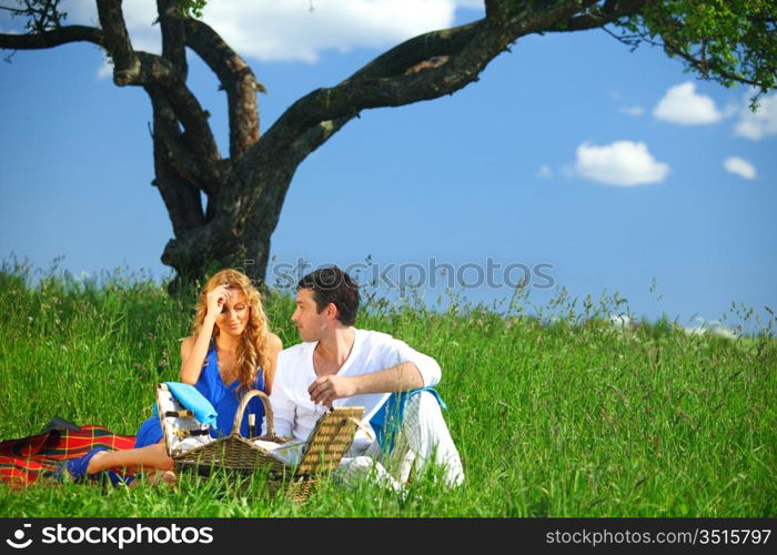 man and woman on picnic in green grass