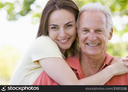 Man and woman outdoors embracing and smiling