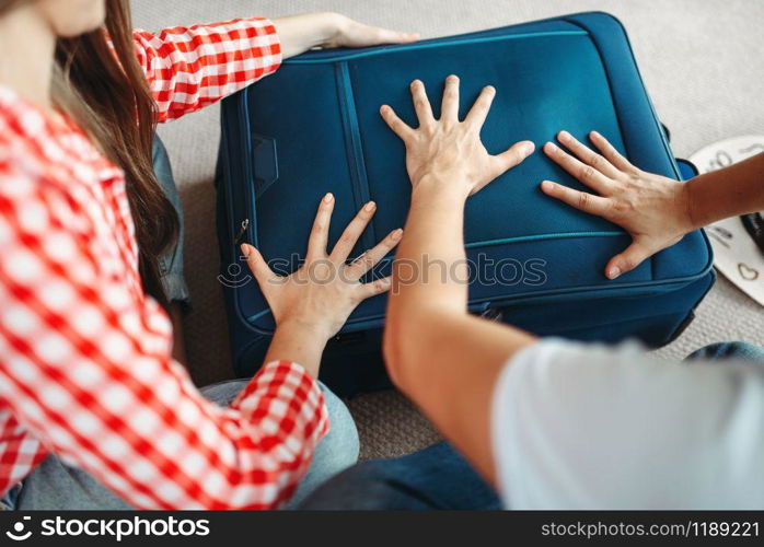 Man and woman packing their suitcases for vacation. Fees on journey concept. Luggage preparation. Man and woman packing their suitcases for vacation