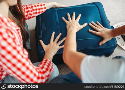 Man and woman packing their suitcases for vacation. Fees on journey concept. Luggage preparation. Man and woman packing their suitcases for vacation
