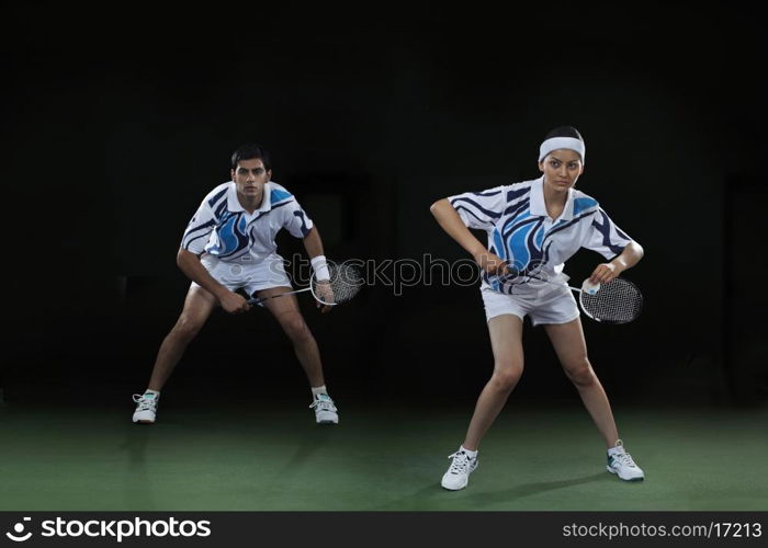 Man and woman playing badminton doubles