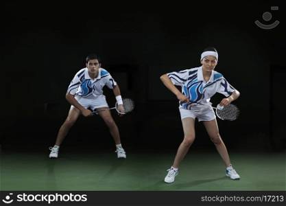 Man and woman playing badminton doubles
