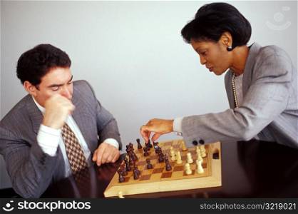 Man and Woman Playing Chess at Work