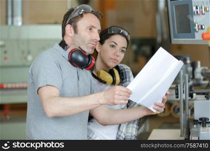 man and woman reading paperwork before using machine