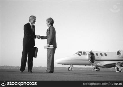 Man And Woman Shaking Hands On Airport Runway