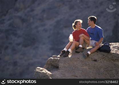 Man and Woman Sitting on a Rock Together