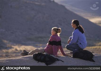 Man and Woman Sitting on Rock Together