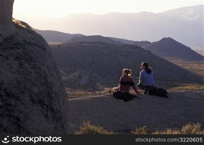 Man and Woman Sitting on Rock Together