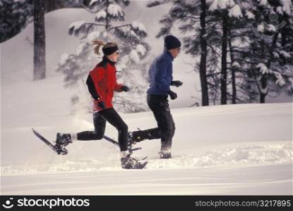 Man and Woman Snowshoeing Together