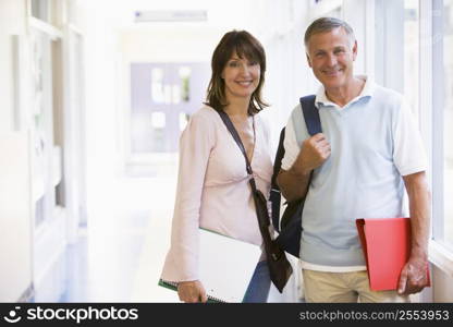 Man and woman standing in corridor with books (high key)