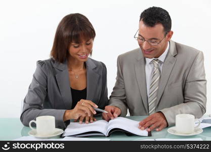 Man and woman studying a book together