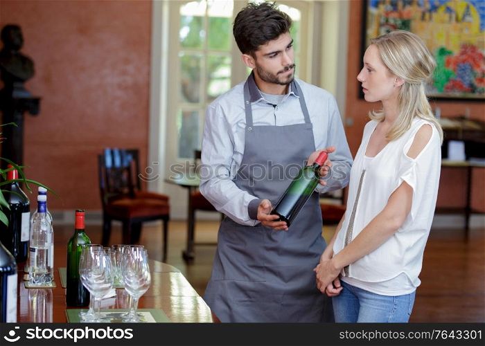 man and woman tasting wine at winery