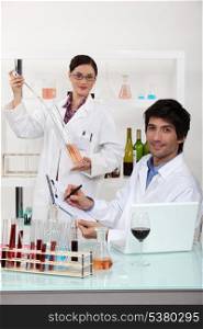 Man and woman testing wine in laboratory
