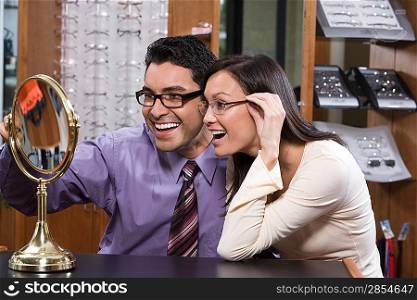 Man and woman trying on eyeglasses in store