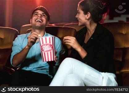 Man and woman watching movie in the movie theater cinema. Group recreation activity and entertainment concept.