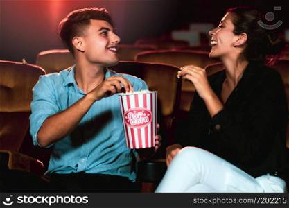 Man and woman watching movie in the movie theater cinema. Group recreation activity and entertainment concept.