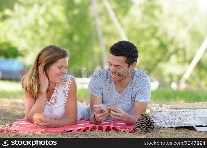 man and woman with a tablet on the grass