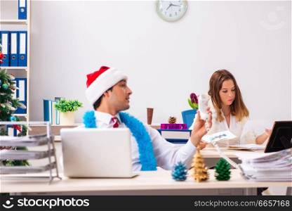 Man and woman working at the office on Cristmass eve 