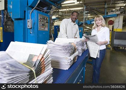 Man and woman working in newspaper factory