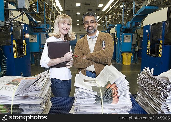 Man and woman working in newspaper factory portrait
