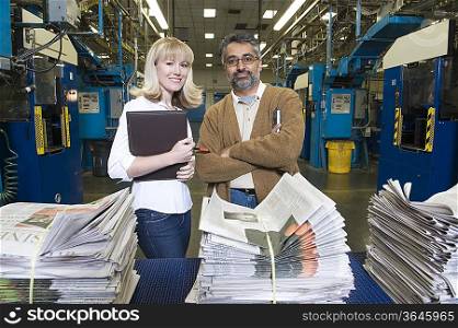 Man and woman working in newspaper factory portrait