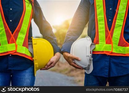 Man and Women Engineer holding hardhat safety Standing outdoor Teamwork management project