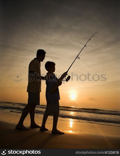 Man and young boy fishing in surf Man and young boy fishing in surf Man and young boy fishing in surf