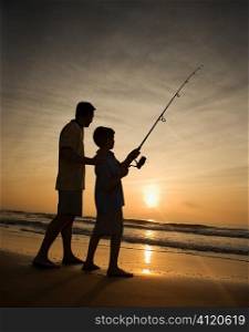 Man and young boy fishing in surf Man and young boy fishing in surf Man and young boy fishing in surf