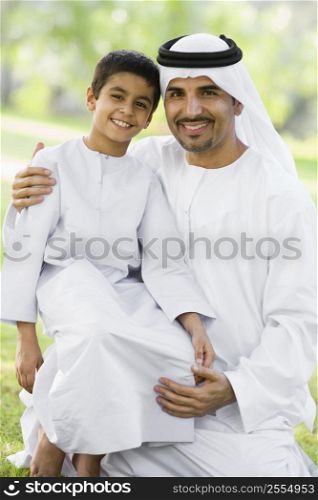 Man and young boy outdoors in a park smiling (selective focus)