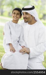 Man and young boy outdoors in a park smiling (selective focus)