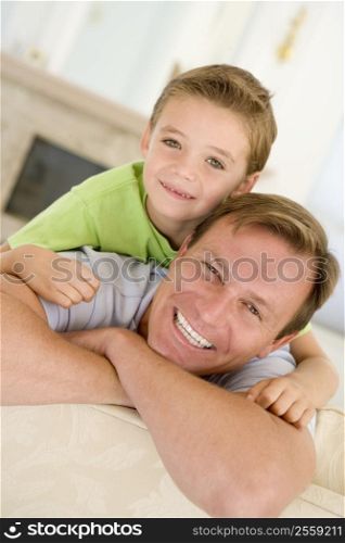 Man and young boy sitting in living room smiling