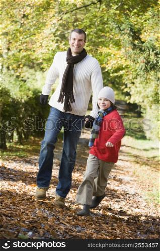Man and young boy walking outdoors in park and smiling