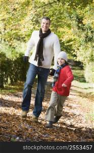 Man and young boy walking outdoors in park and smiling