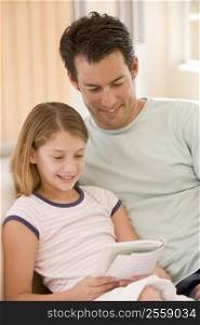 Man and young girl in living room reading book and smiling