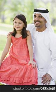 Man and young girl outdoors in a park smiling (selective focus)