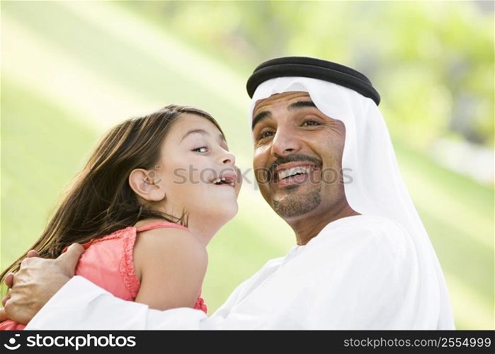 Man and young girl outdoors in park playing and smiling (selective focus)